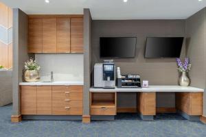 a kitchen with a counter with a coffee maker and a sink at Sandman Signature Mississauga Hotel in Mississauga