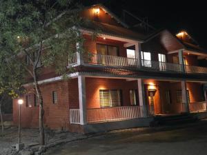 a brick house with a balcony at night at Aanandi Resort in Shirdi