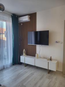 a living room with a flat screen tv on a wall at Apartment 10 in Inđija