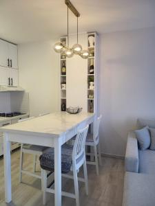 a white dining room table with chairs and a couch at Apartment 10 in Inđija