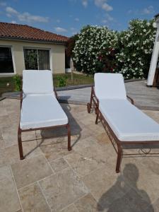 two white chairs sitting on top of a patio at Casa Brens in Brens +2 photos