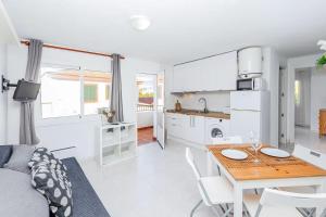 eine Küche und ein Wohnzimmer mit einem Tisch und einer Küche in der Unterkunft TRANQUILO APARTAMENTO con preciosa cala en la puerta in Ciutadella