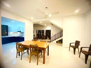a dining room with a wooden table and chairs at Emerald Sea Breeze - Madiha in Nikawatawana