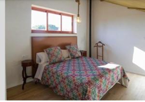 a bedroom with a bed with a comforter and a window at El Campirri in Daimés +22 photos