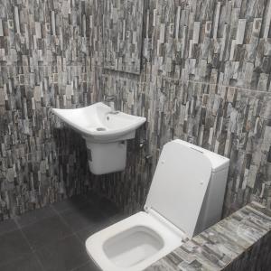 a bathroom with a white toilet and a sink at Emerald Sea Breeze - Madiha in Nikawatawana +3 photos