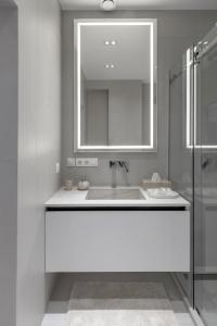 a white bathroom with a sink and a mirror at Renest Milano Elegance Stay in Chişinău