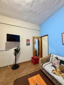 a living room with a couch and a blue wall at Mini loft moderno y equipado in Fernando de la Mora