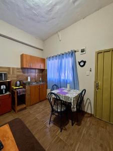 a kitchen with a table with chairs and a blue curtain at Mini loft moderno y equipado in Fernando de la Mora