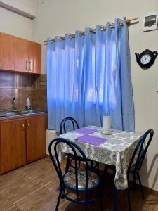 a kitchen with a table with chairs and a blue curtain at Mini loft moderno y equipado in Fernando de la Mora +2 photos
