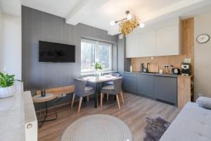 a kitchen and dining room with a table and chairs at Kurort Kozubnik Daglezja D23 Vista Stay in Porąbka