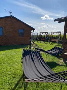 a hammock in a field next to a building at Domki pod Dębem in Wilkasy