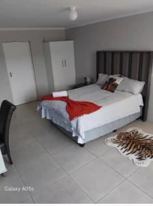 a bedroom with a bed with a red blanket on it at Little Waters Bnb in Queenstown