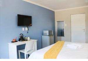a hotel room with a bed and a tv on the wall at Little Waters Bnb in Queenstown