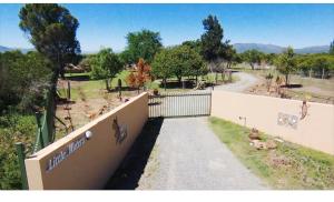 a fence with a gate and a road with animals at Little Waters Bnb in Queenstown