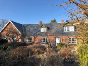 a red brick house with a black roof at Vejlø Skole - Degnegaarden in Næstved