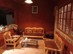 a living room with chairs and a couch and a table at Casa Shaullo-Chalets in Los Baños del Inca +7 photos