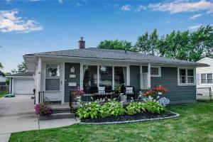 a house with a porch with flowers and plants at New 3BDRM Centrally Located Free Parking AC in Buffalo