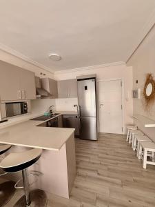 a kitchen with a counter and a refrigerator at Turquesa 10 in La Pineda