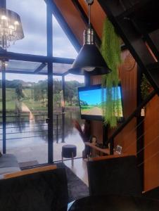 a living room with a tv and a large window at Verde Vale in Nova Petrópolis