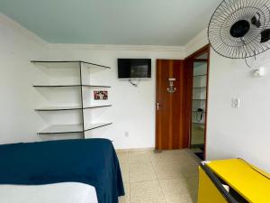 a bedroom with a bed and a fan at Pousada Bellmar Peró - Praia e Comércio 8 min andando in Cabo Frio