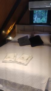 a large white bed with two towels on it at Verde Vale in Nova Petrópolis