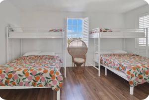 a bedroom with two bunk beds and a chair at Simply Adventurous Too in Mexico Beach
