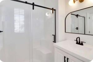 a white bathroom with a sink and a shower at Simply Adventurous Too in Mexico Beach