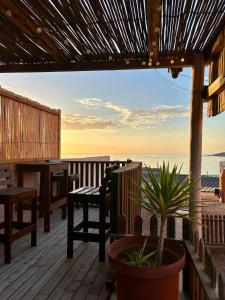 a deck with a table and a bench and the ocean at Seabreeze Accommodation in Lüderitz