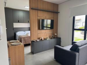 a bedroom with a bed and a tv on a wall at Condomínio Noruega - casas 2 dormitórios in Jaguarão