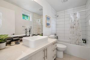 a white bathroom with a sink and a toilet at 3BR Queen Anne House with Rooftop access in Seattle +25 photos