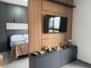 a bedroom with a bed and a television on a wall at Condomínio Noruega - casas 2 dormitórios in Jaguarão