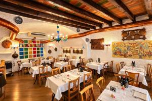 a restaurant with white tables and chairs and a chandelier at Vinessa Rooms in Sirmione
