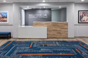 a lobby with a white table and a welcome sign at Hampton Inn & Suites Charlottesville at the University in Charlottesville
