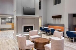 a waiting room with chairs and a fireplace at Hampton Inn & Suites Charlottesville at the University in Charlottesville