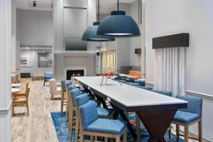 a dining room with a long table and chairs at Hampton Inn & Suites Charlottesville at the University in Charlottesville