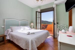 a bedroom with a bed and a balcony at Hotel Rural Sierra Tejeda in Alcaucín +66 photos