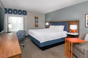 a hotel room with a bed and a couch at Hampton Inn & Suites Charlottesville at the University in Charlottesville +34 photos