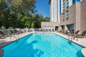 a swimming pool with chairs and a building at Hampton Inn & Suites Charlotte Arrowood Rd in Charlotte