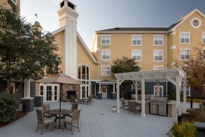 a patio with a table and chairs in front of a building at Homewood Suites by Hilton Raleigh/Cary in Cary