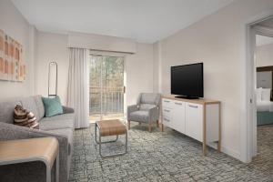 a living room with a tv and a couch and chair at Homewood Suites by Hilton Raleigh/Cary in Cary