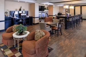 a hotel lobby with chairs and tables and a bar at Hampton Inn Pecos in Pecos