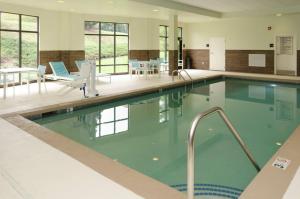 a large swimming pool with blue chairs and tables at Hampton Inn Hickory in Hickory