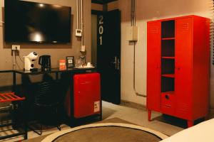 a room with a red cabinet and a tv at LOFT Hotel by Sommelier Hoteles in Santiago