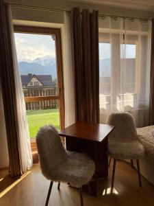 a bedroom with a table and two chairs and a window at La Kozica in Kościelisko