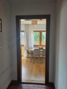 a dining room with a table and chairs and a window at La Kozica in Kościelisko +16 photos