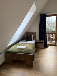 a bedroom with a bed under a roof at La Kozica in Kościelisko