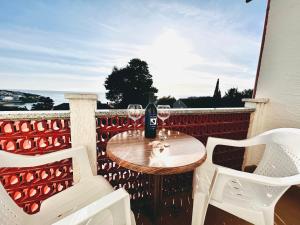 a table with two glasses of wine on a balcony at room MLIN 2 in Jakišnica