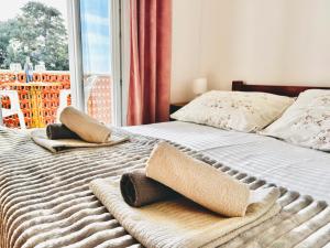 a bed with two pillows on it with a window at room MLIN 2 in Jakišnica +3 photos