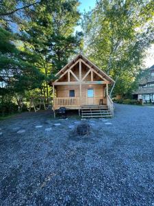 a log cabin with a porch and a large yard at Terrawoods Pine Cottage in Parry Sound