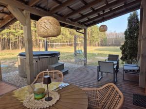 a patio with a table and chairs on a deck at Szyszkowy Domek in Milejczyce